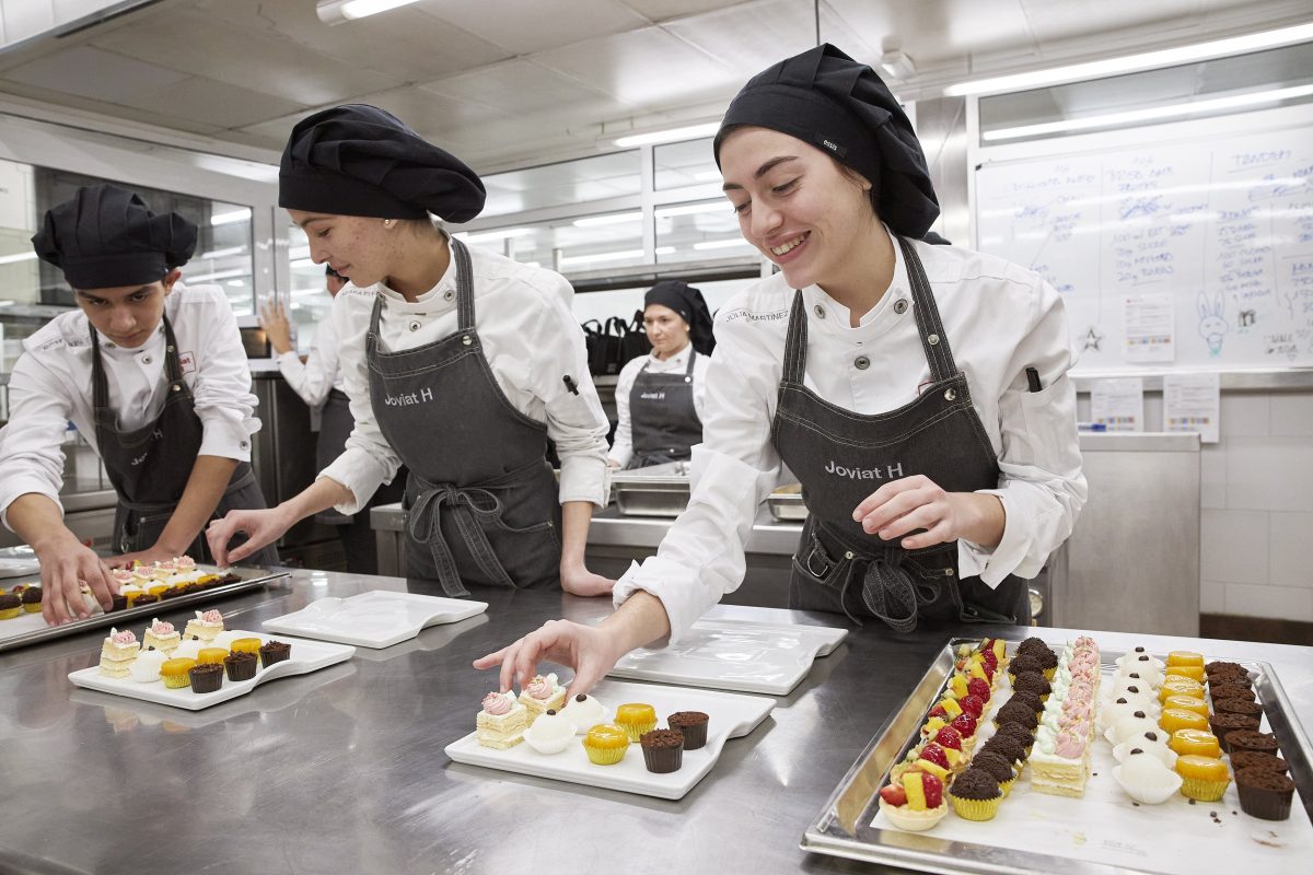 Students presenting chocolates in pastry laboratory.