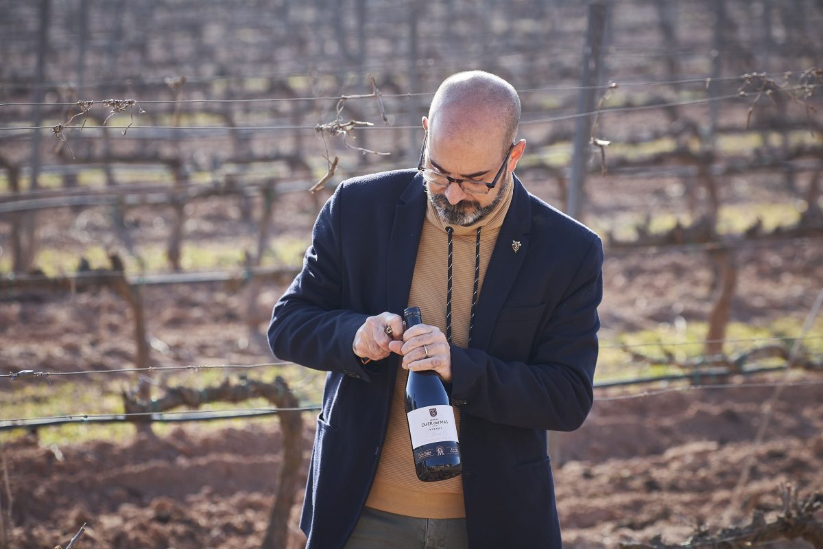 Josep Pelegrín uncorking a bottle of wine in the Oller del Mas vineyard
